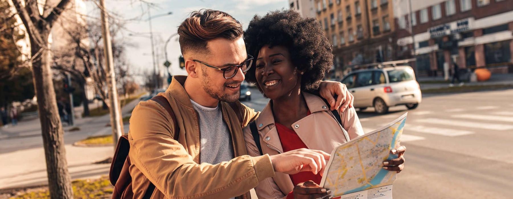 a man and woman looking at a map in the city